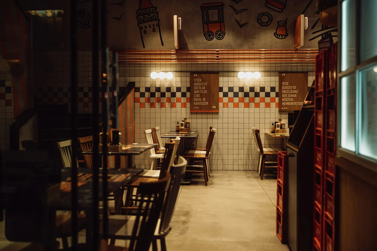 An empty restaurant dining room with bare wooden tables and chairs, no diners present
