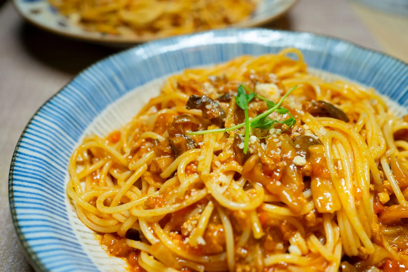 A plate of spaghetti in tomato sauce, the base a tin of sardines melts into