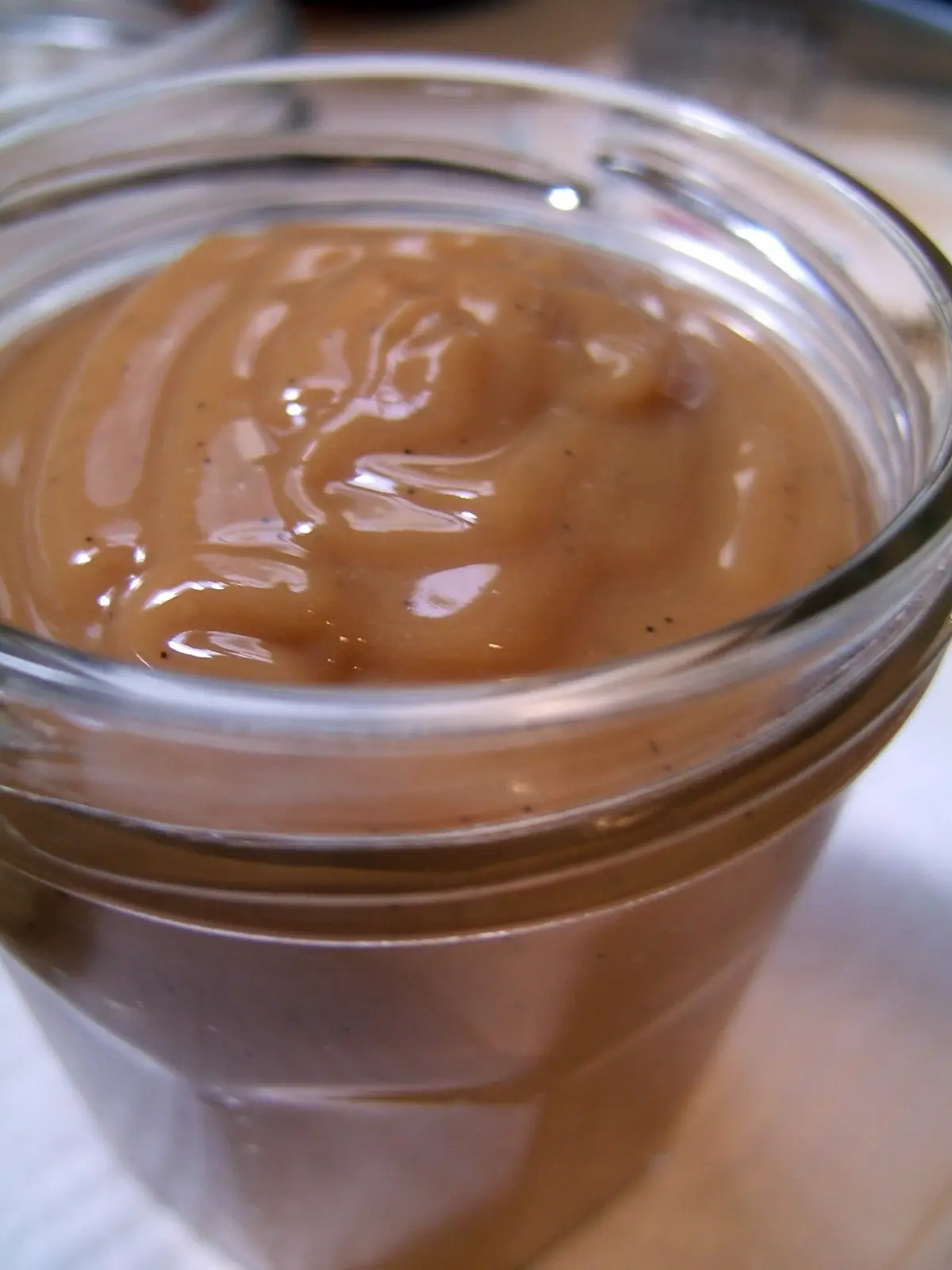 A glass jar of thick, glossy arequipe, Colombia's dulce de leche caramel