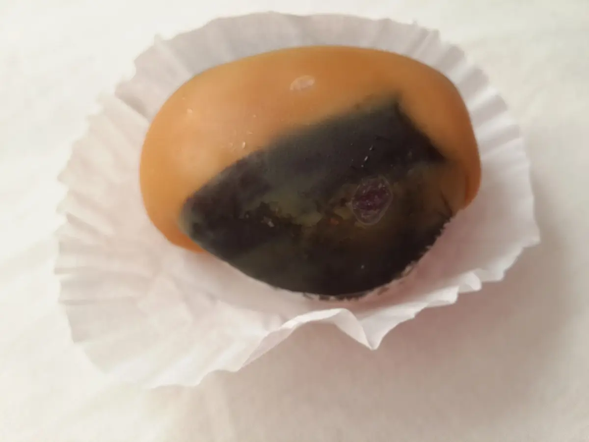 A fig (breva) cooked in syrup and filled with arequipe in a paper liner