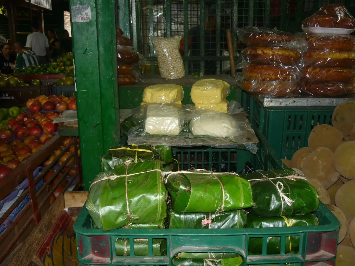 Fresh cuajada curd cheese wrapped in banana leaf at a Colombian market