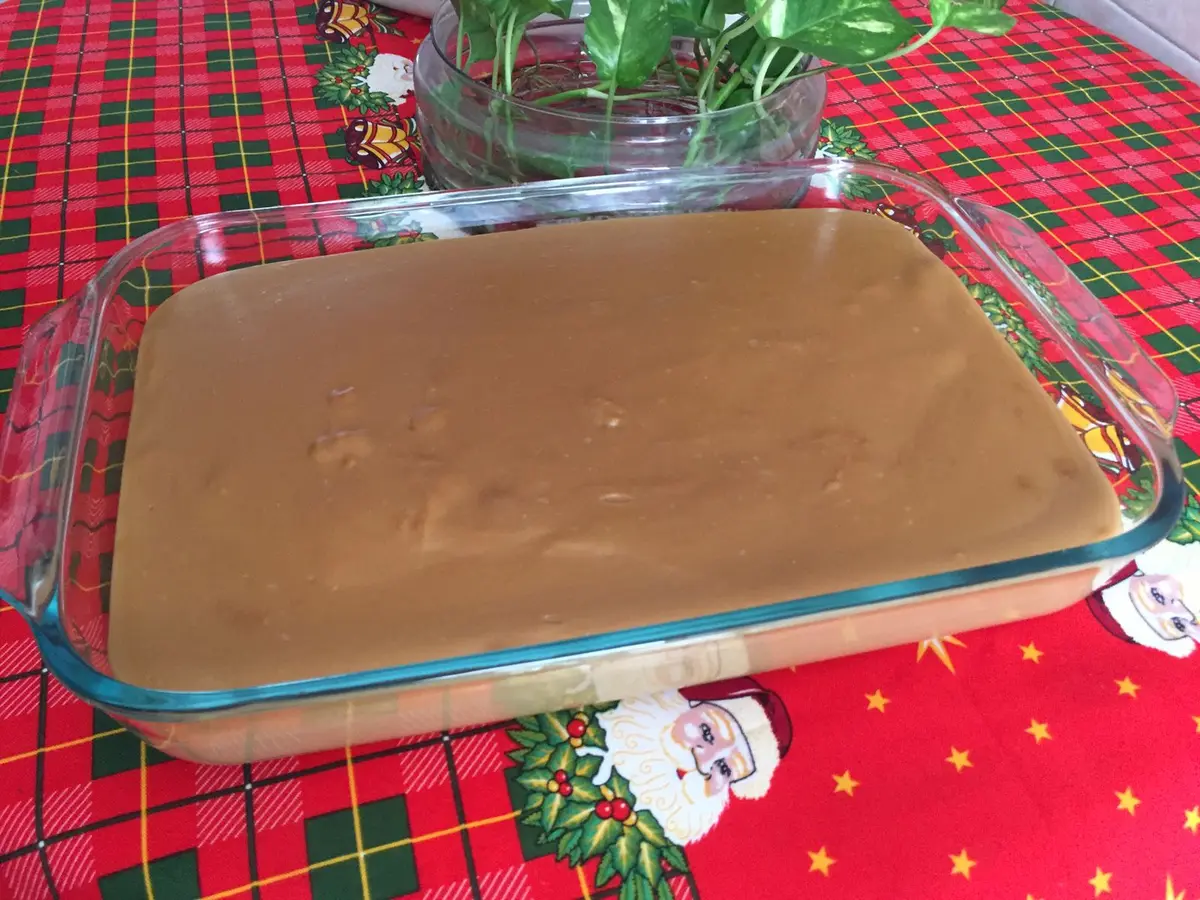 A glass dish of set Colombian natilla custard on a Christmas tablecloth