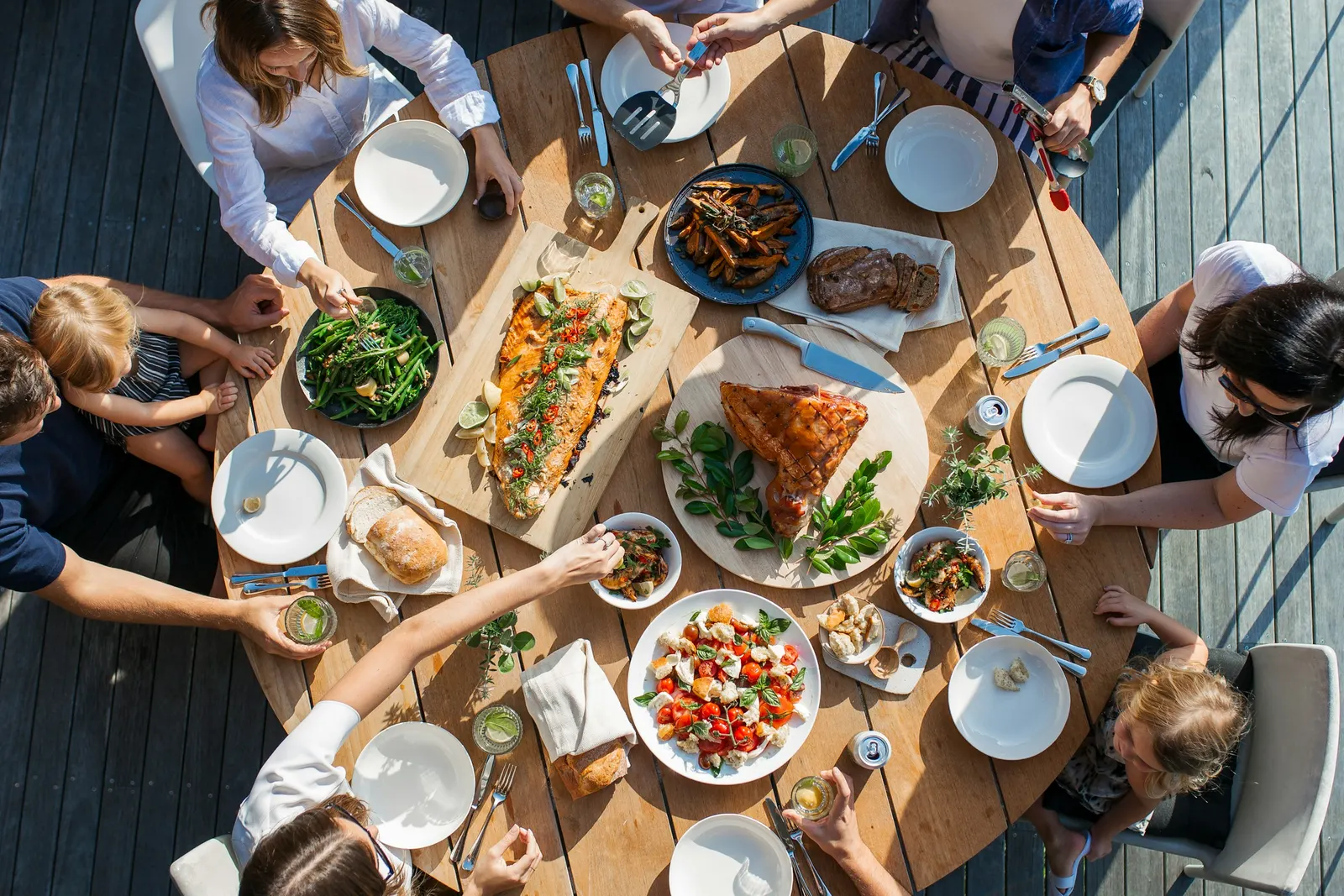 An overhead view of a table covered with many shared dishes, set for a communal celebratory meal