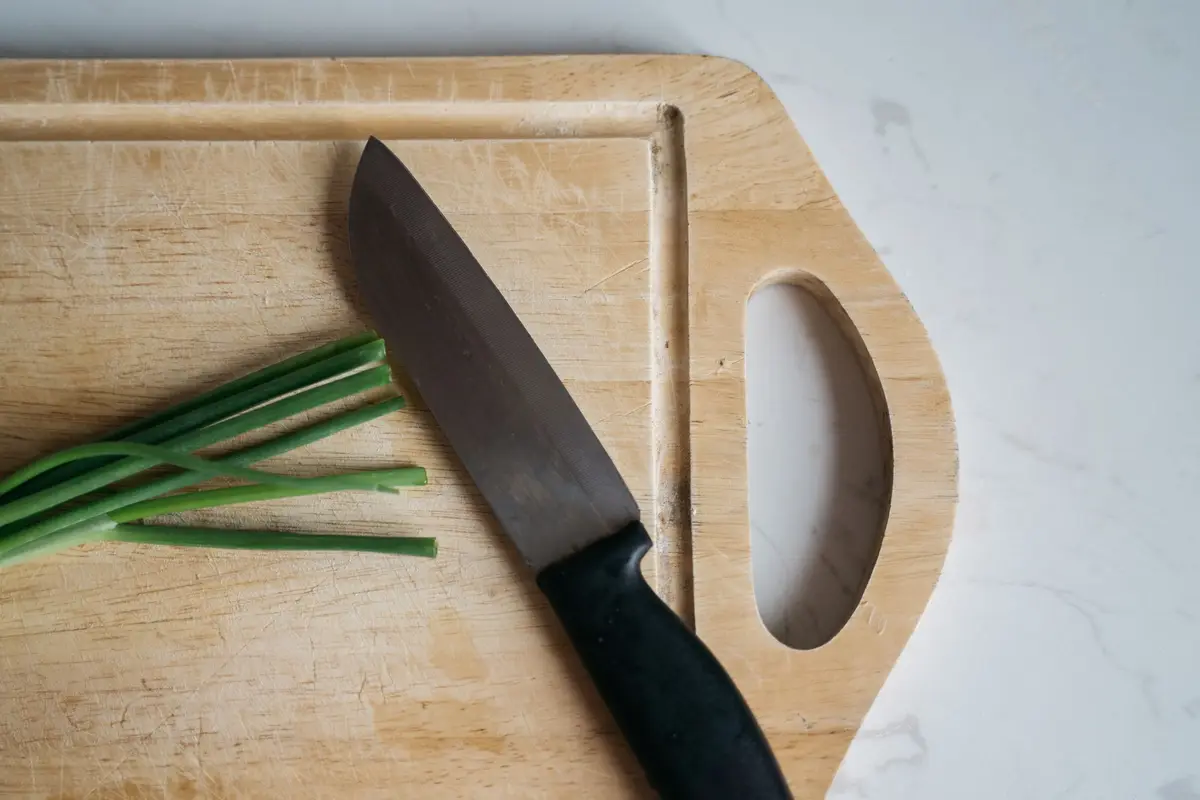 A sharp kitchen knife on a wooden cutting board, the single tool that makes skinning and breaking down a rabbit easy